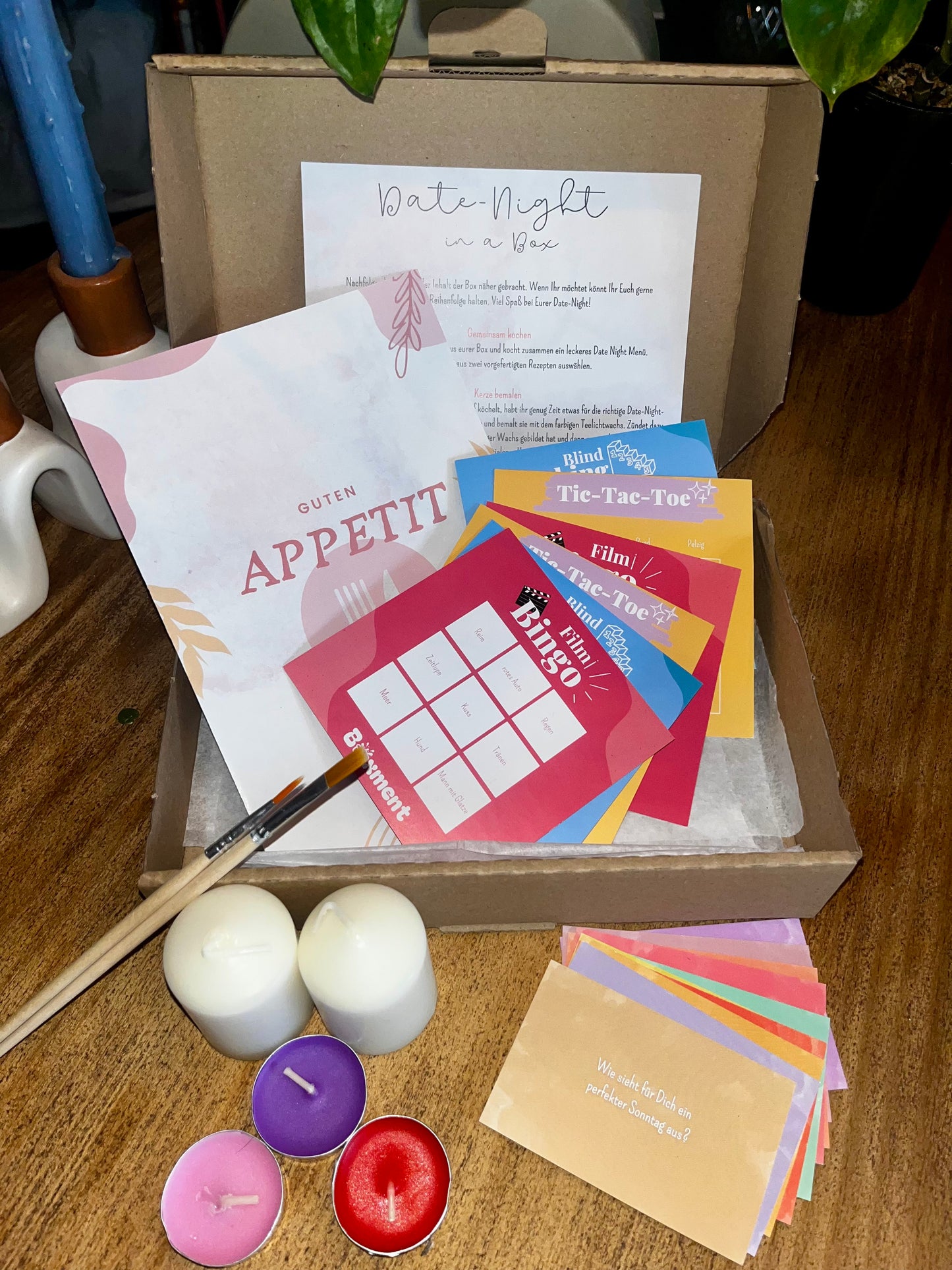 Inhalt des Produktes, es zeigt die Spielkarten, Rezeptkarte, Gesprächskarten und das DIY Kerze bemalen Set